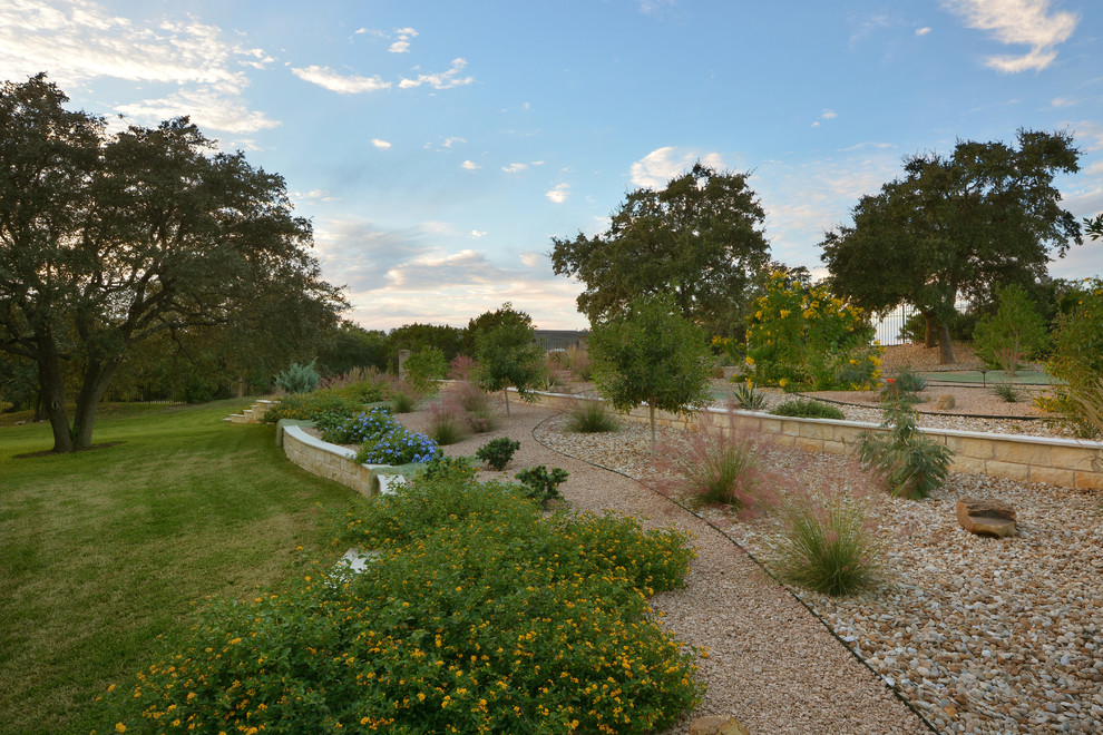 Design ideas for a mid-sized modern front yard full sun xeriscape in Austin with gravel.