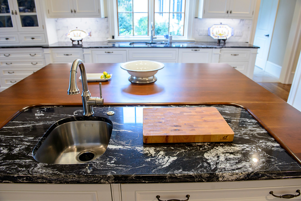 Transitional medium tone wood floor kitchen photo in Atlanta with an undermount sink, granite countertops, white backsplash, stainless steel appliances and an island