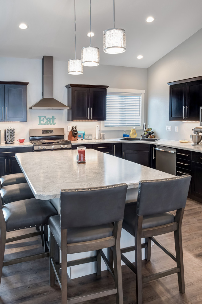 Inspiration for a large transitional l-shaped medium tone wood floor open concept kitchen remodel with a double-bowl sink, shaker cabinets, dark wood cabinets, quartzite countertops, stainless steel appliances and an island