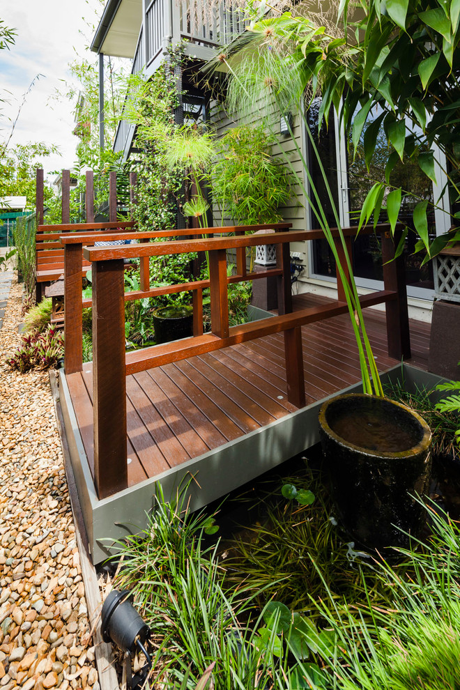 Inspiration for an asian partial sun garden in Brisbane with a water feature and gravel.