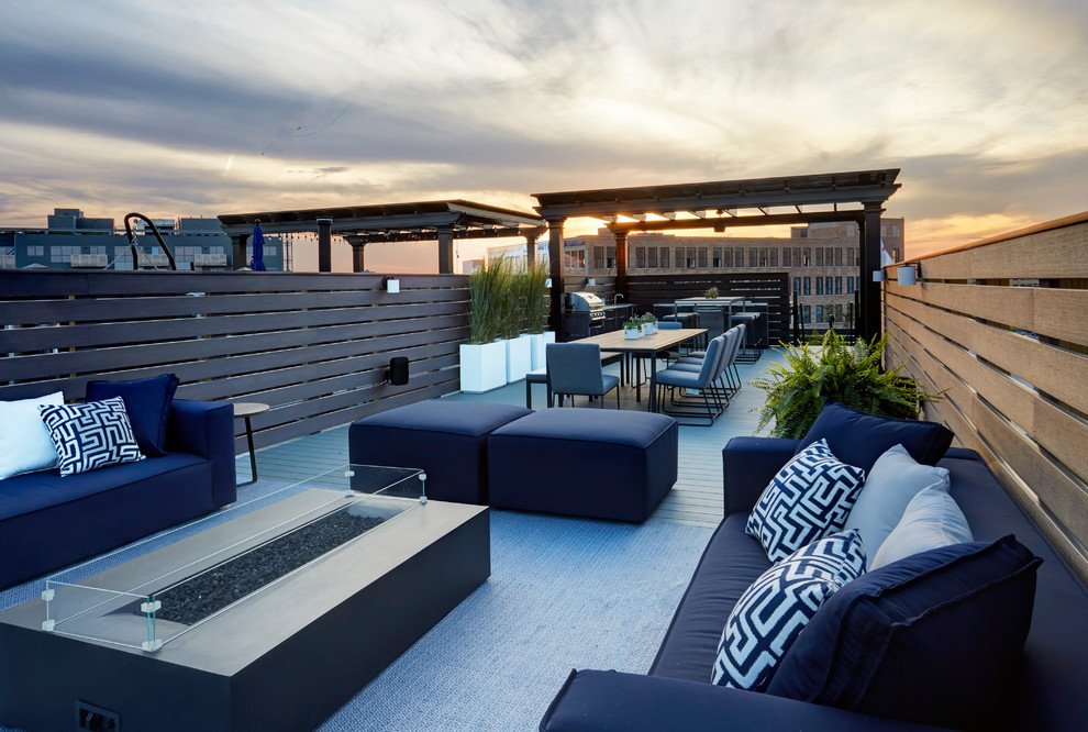 This is an example of a large contemporary rooftop deck in Chicago with a fire feature and no cover.