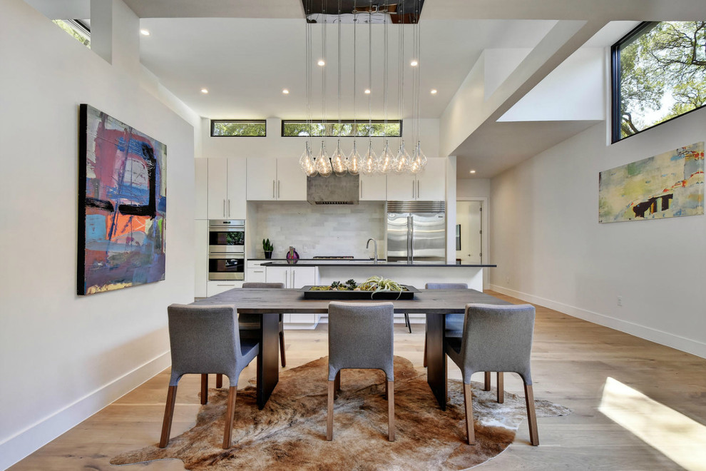 Inspiration for a contemporary kitchen/dining combo in Austin with white walls, light hardwood floors and no fireplace.