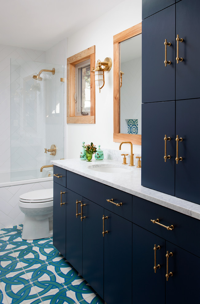 Inspiration for a mid-sized transitional bathroom in Austin with flat-panel cabinets, blue cabinets, an alcove tub, a shower/bathtub combo, white tile, porcelain tile, white walls, porcelain floors, an undermount sink, marble benchtops and an open shower.