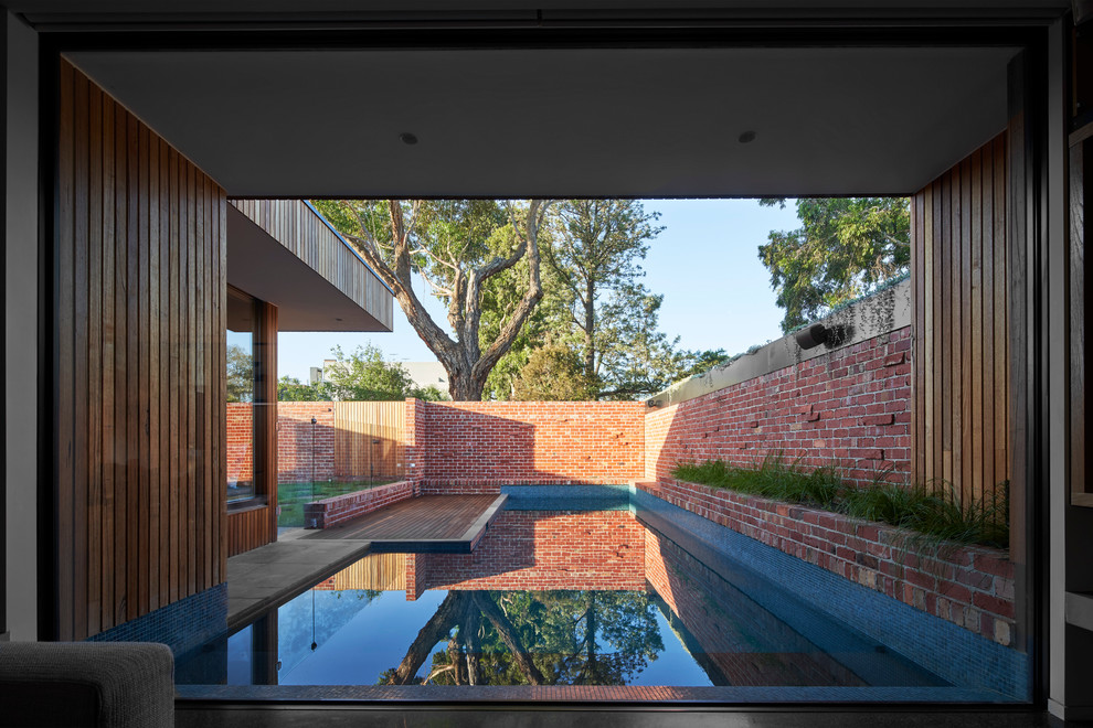 Inspiration for a contemporary custom-shaped pool in Melbourne with brick pavers.