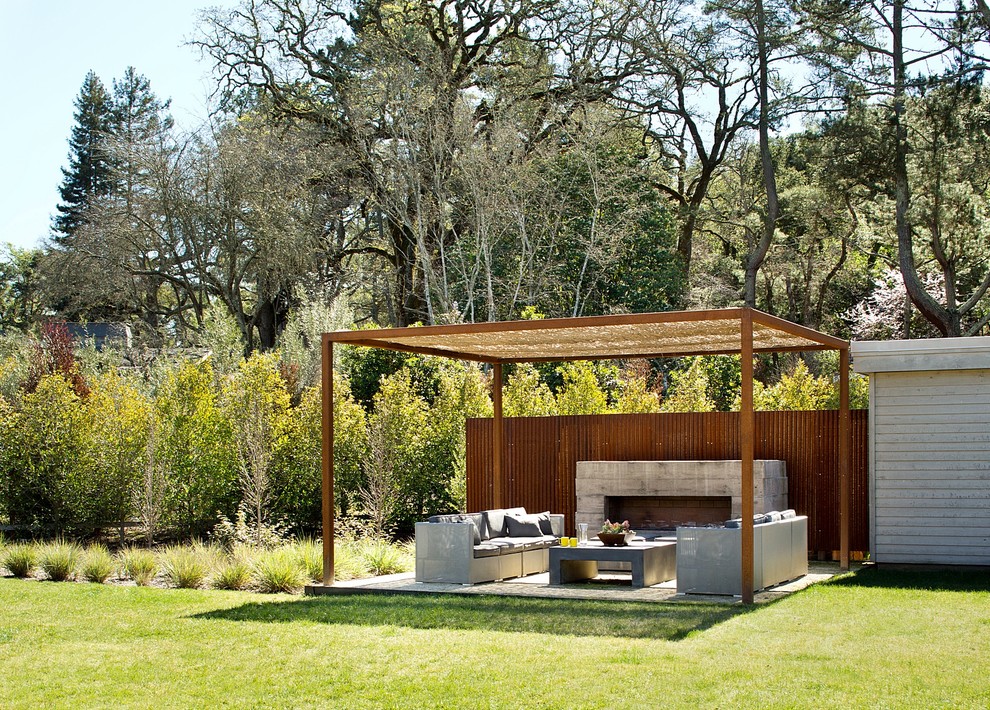 Inspiration for a mid-sized contemporary backyard patio in Boston with a pergola and with fireplace.
