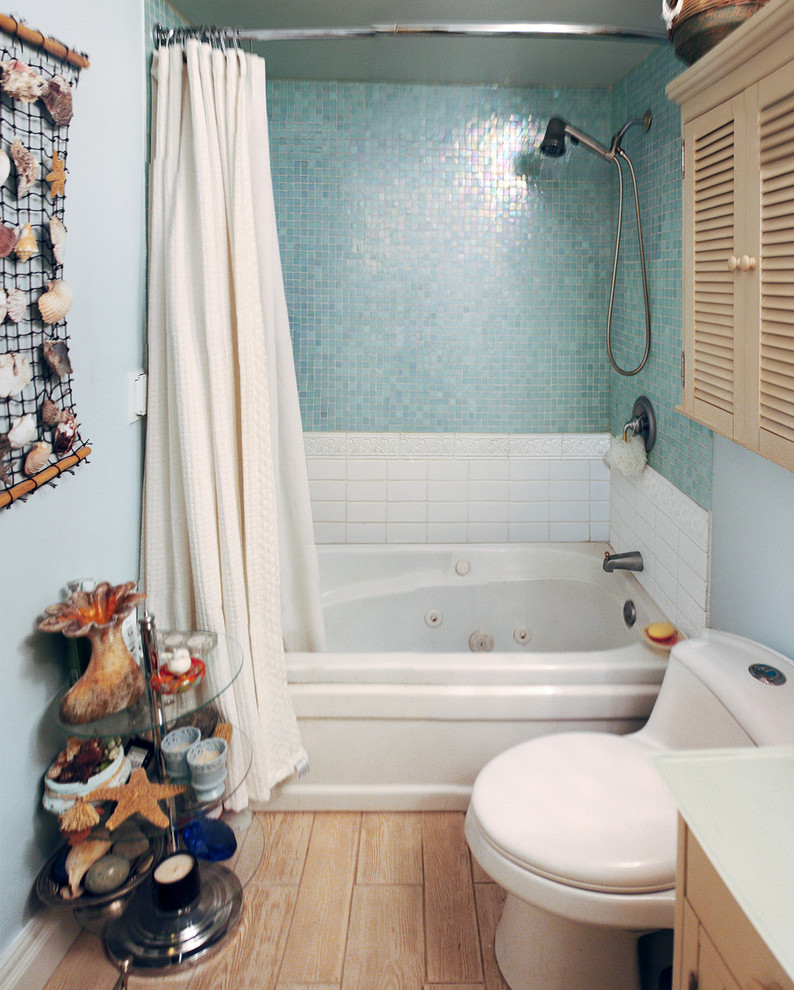 Small eclectic master blue tile and glass tile medium tone wood floor bathroom photo in Other with a drop-in sink, raised-panel cabinets, beige cabinets, glass countertops, a hot tub and blue walls