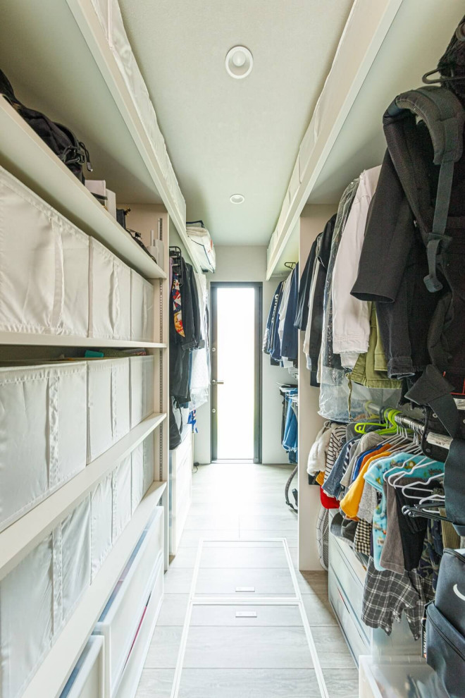 This is an example of a medium sized industrial gender neutral walk-in wardrobe in Tokyo Suburbs with open cabinets, light hardwood flooring, beige floors, a wallpapered ceiling and feature lighting.