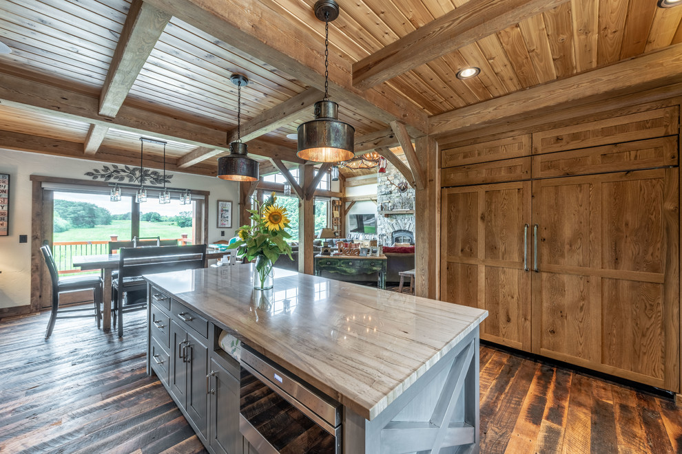 Mid-sized country u-shaped eat-in kitchen in Milwaukee with a farmhouse sink, beaded inset cabinets, distressed cabinets, quartzite benchtops, brown splashback, ceramic splashback, panelled appliances, dark hardwood floors, with island, brown floor and grey benchtop.