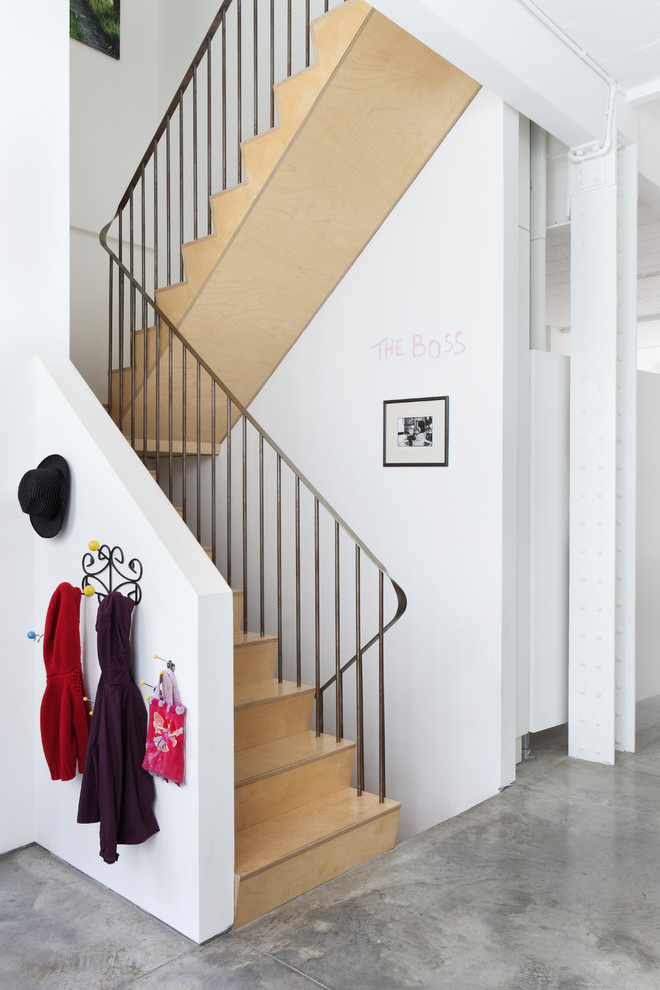 Photo of a mid-sized industrial wood u-shaped staircase in London with wood risers.