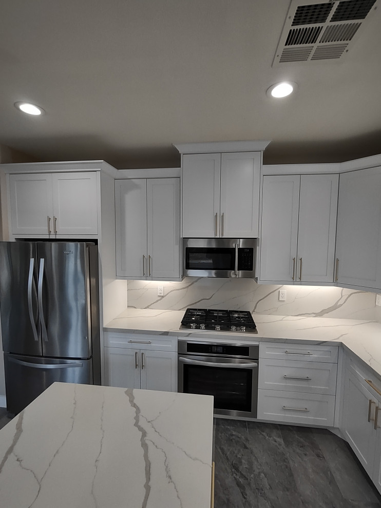 Design ideas for a mid-sized traditional l-shaped kitchen in Las Vegas with an undermount sink, shaker cabinets, white cabinets, stainless steel appliances and with island.
