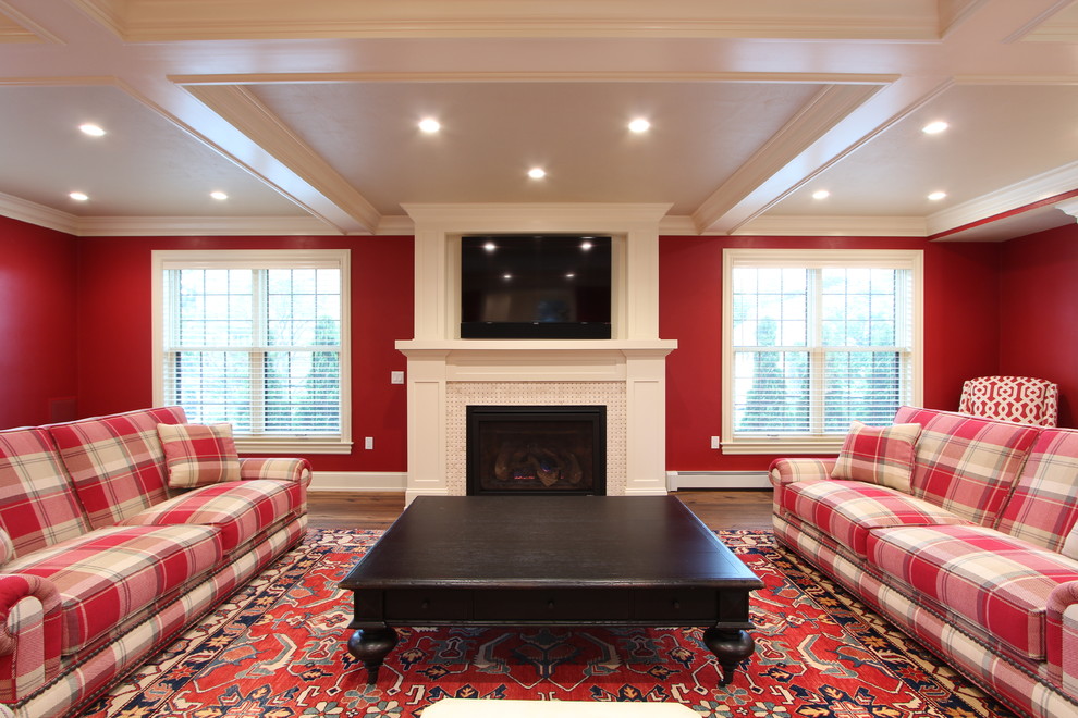 Inspiration for a large transitional enclosed family room in Other with red walls, medium hardwood floors, a standard fireplace, a tile fireplace surround, a wall-mounted tv and brown floor.