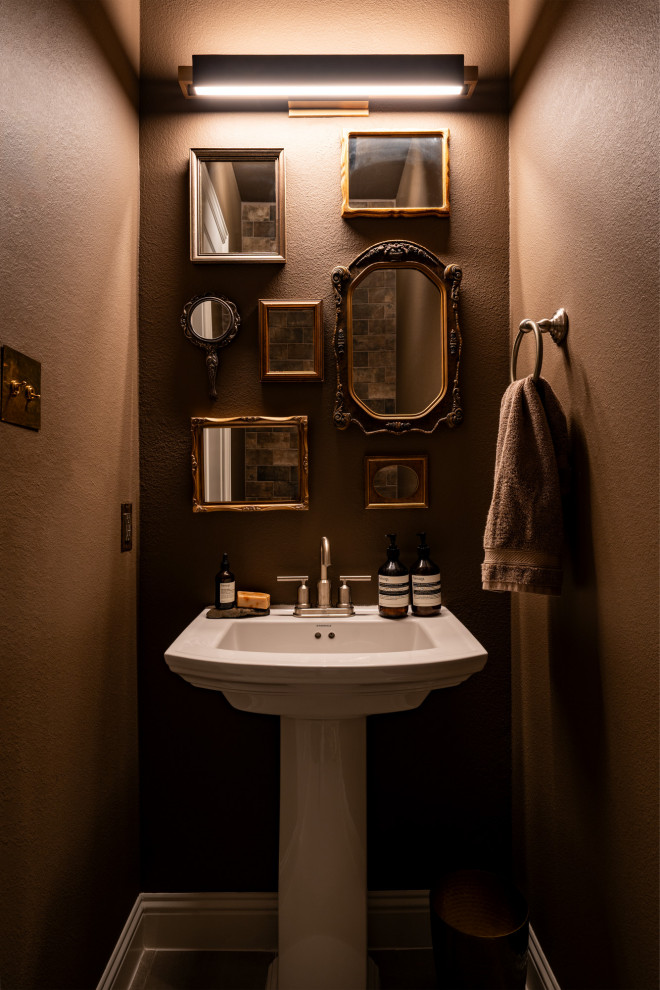 Inredning av ett 50 tals litet toalett, med brun kakel, travertinkakel, bruna väggar och ett piedestal handfat