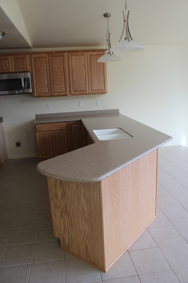 Example of a classic kitchen design with an integrated sink and solid surface countertops