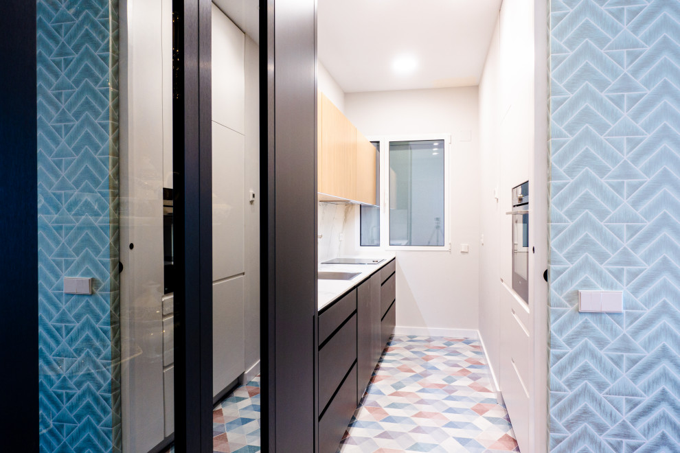 Immagine di una cucina parallela design di medie dimensioni con lavello sottopiano, elettrodomestici da incasso, pavimento in gres porcellanato, nessuna isola e pavimento multicolore