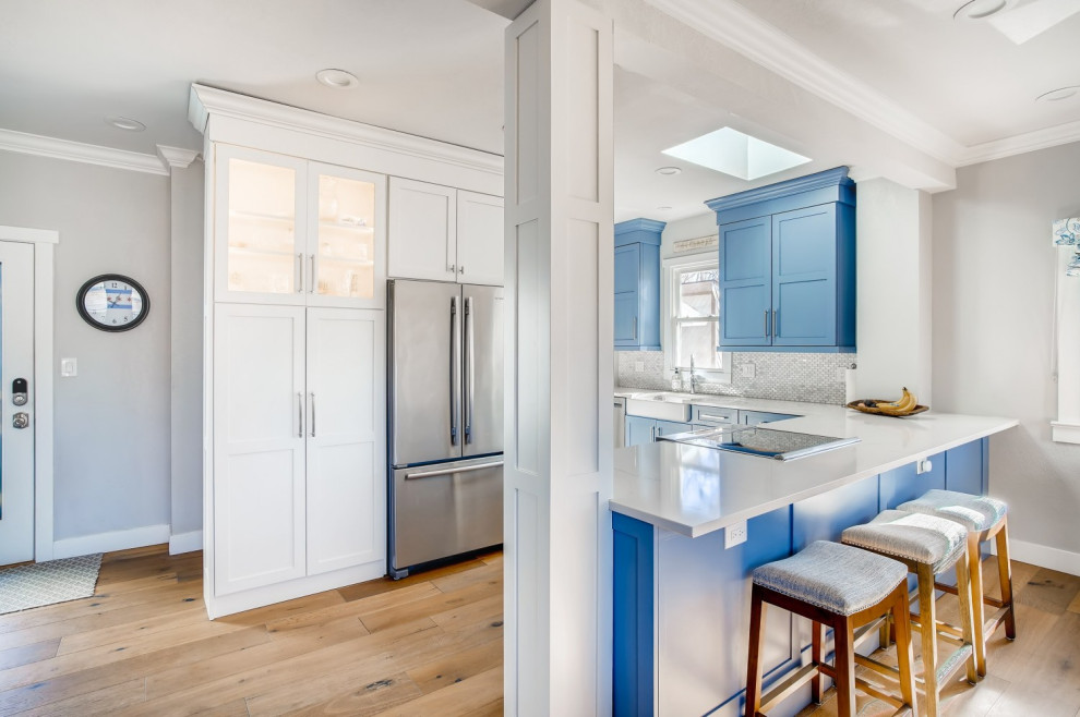 Inspiration for a classic l-shaped kitchen/diner in Denver with shaker cabinets, blue cabinets, engineered stone countertops, white splashback, mosaic tiled splashback, brown floors and white worktops.