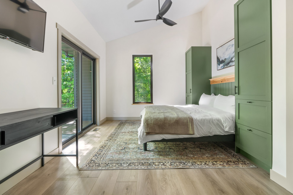 Идея дизайна: хозяйская спальня среднего размера в современном стиле с белыми стенами, полом из винила, коричневым полом и сводчатым потолком