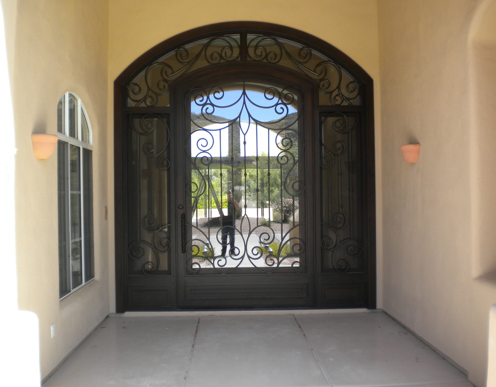 Inspiration for a large rustic concrete floor front door remodel in Phoenix with beige walls and a black front door