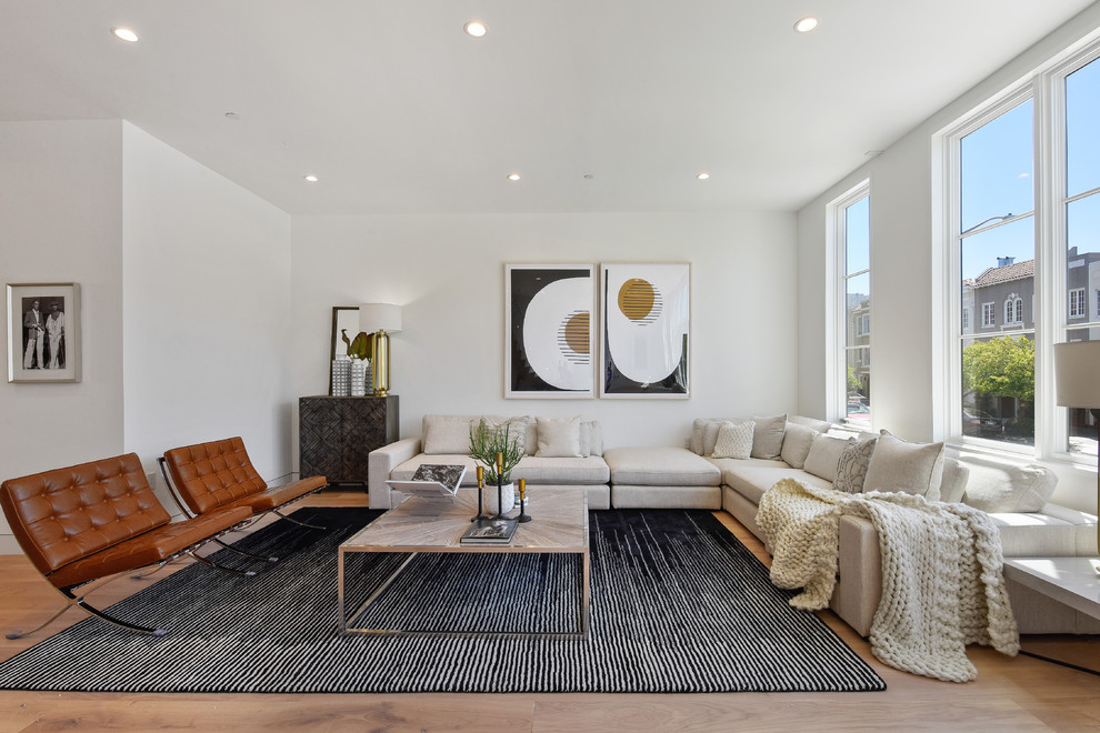 Contemporary formal open concept living room in San Francisco with white walls, light hardwood floors and beige floor.