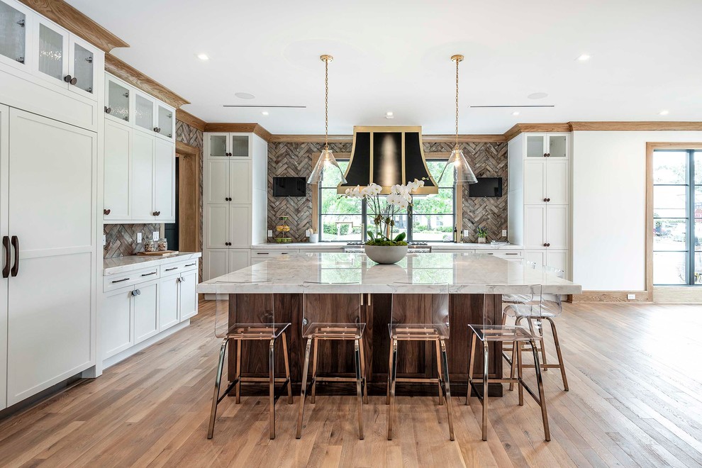 This is an example of a transitional kitchen in Orlando with shaker cabinets, white cabinets, brown splashback, panelled appliances, medium hardwood floors, with island, white benchtop and marble benchtops.