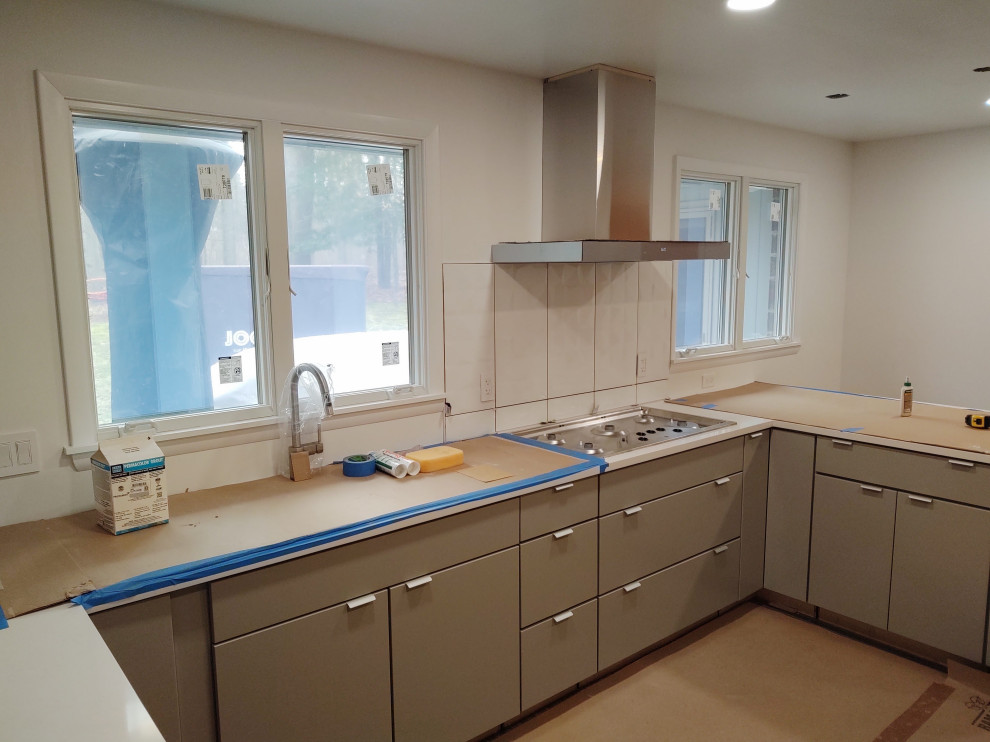 Enclosed kitchen - mid-sized enclosed kitchen idea with flat-panel cabinets, gray cabinets and a peninsula