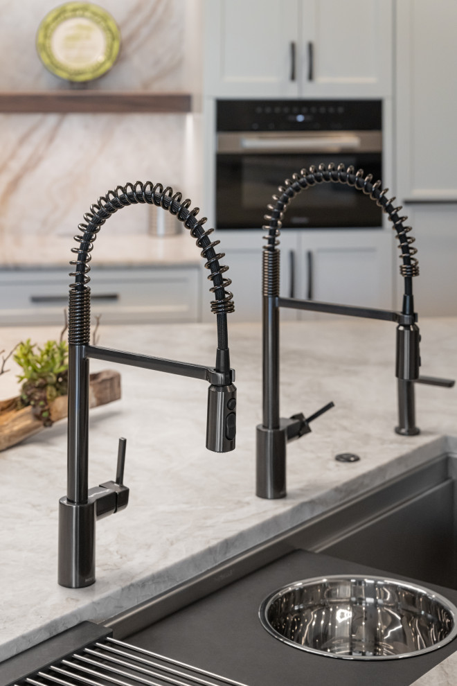 Inspiration for a large transitional medium tone wood floor and brown floor open concept kitchen remodel with a double-bowl sink, flat-panel cabinets, white cabinets, quartzite countertops, beige backsplash, stainless steel appliances, an island and beige countertops
