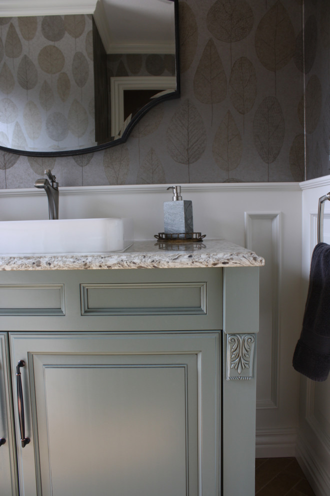 Inspiration for a small classic cloakroom in Wichita with raised-panel cabinets, green cabinets, engineered stone worktops, multi-coloured worktops, a freestanding vanity unit, a two-piece toilet, multi-coloured walls, travertine flooring, a vessel sink, brown floors and wallpapered walls.