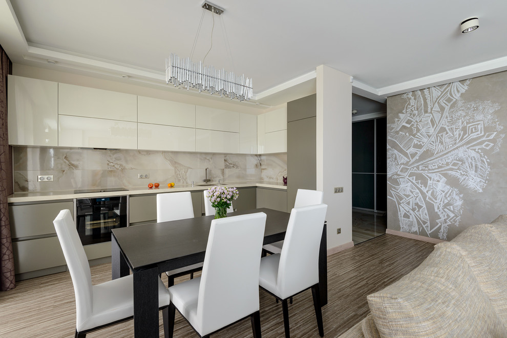 Inspiration for a mid-sized contemporary l-shaped open plan kitchen in Novosibirsk with an undermount sink, flat-panel cabinets, beige cabinets, solid surface benchtops, beige splashback, ceramic splashback, stainless steel appliances, cork floors, no island, beige floor and beige benchtop.