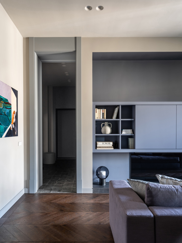 Стильный дизайн: парадная, открытая, объединенная гостиная комната среднего размера в современном стиле с серыми стенами, темным паркетным полом, горизонтальным камином, фасадом камина из плитки, скрытым телевизором и коричневым полом - последний тренд