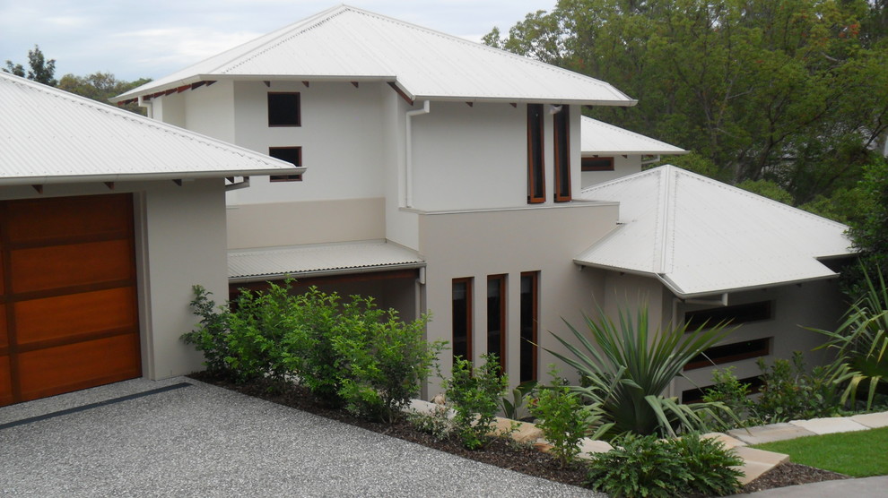 Photo of a large contemporary two-storey beige house exterior in Brisbane with concrete fiberboard siding, a hip roof and a metal roof.
