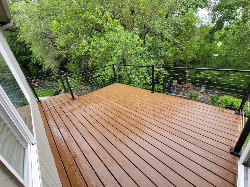 Inspiration for a mid-sized contemporary backyard and first floor deck in Omaha with no cover and cable railing.