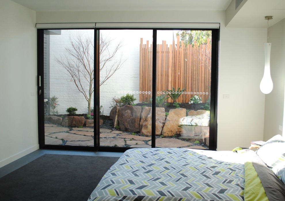 Small contemporary master bedroom in Melbourne with white walls, carpet, no fireplace and grey floor.