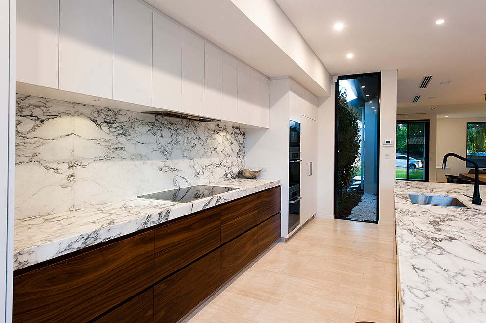Photo of a large modern galley eat-in kitchen in Perth with a double-bowl sink, flat-panel cabinets, dark wood cabinets, marble benchtops, white splashback, stone slab splashback, stainless steel appliances, porcelain floors and with island.