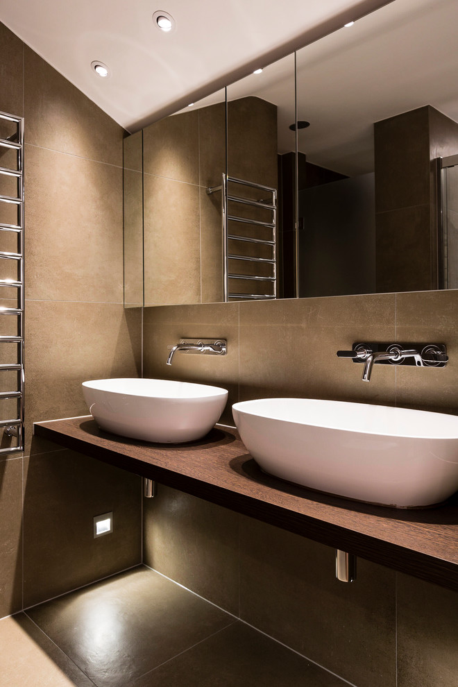 Design ideas for a contemporary bathroom in London with a vessel sink, wood benchtops, brown tile and brown benchtops.