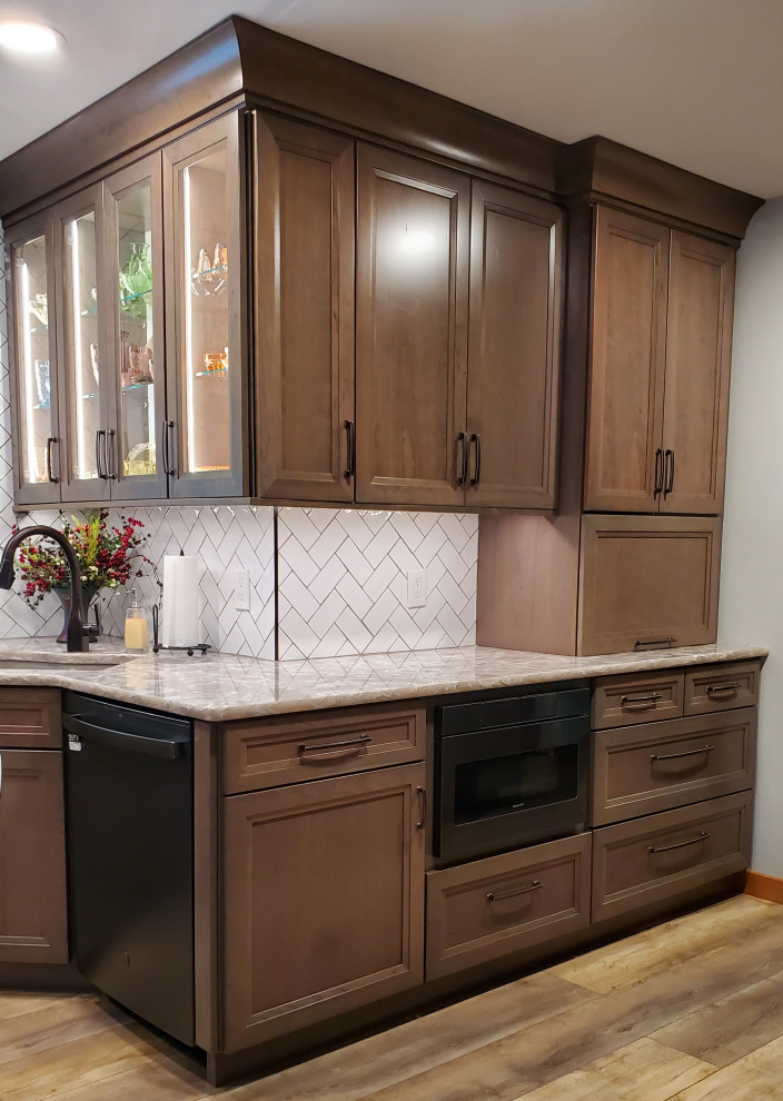 Open concept kitchen - mid-sized transitional vinyl floor and beige floor open concept kitchen idea with an undermount sink, recessed-panel cabinets, gray cabinets, quartz countertops, white backsplash, subway tile backsplash, black appliances, an island and beige countertops