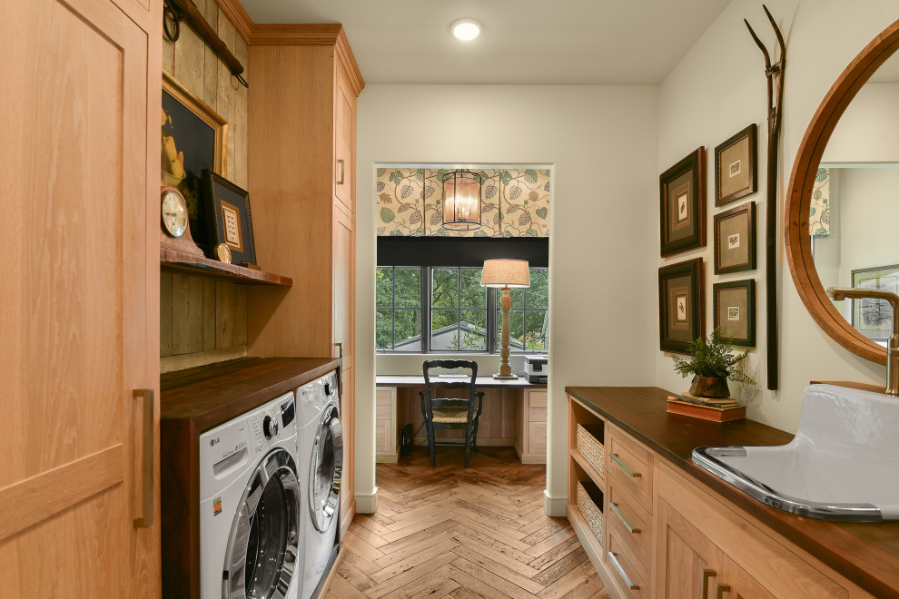 Large country galley utility room in Atlanta with a farmhouse sink, shaker cabinets, light wood cabinets, wood benchtops, timber splashback, white walls, medium hardwood floors, a side-by-side washer and dryer and brown benchtop.