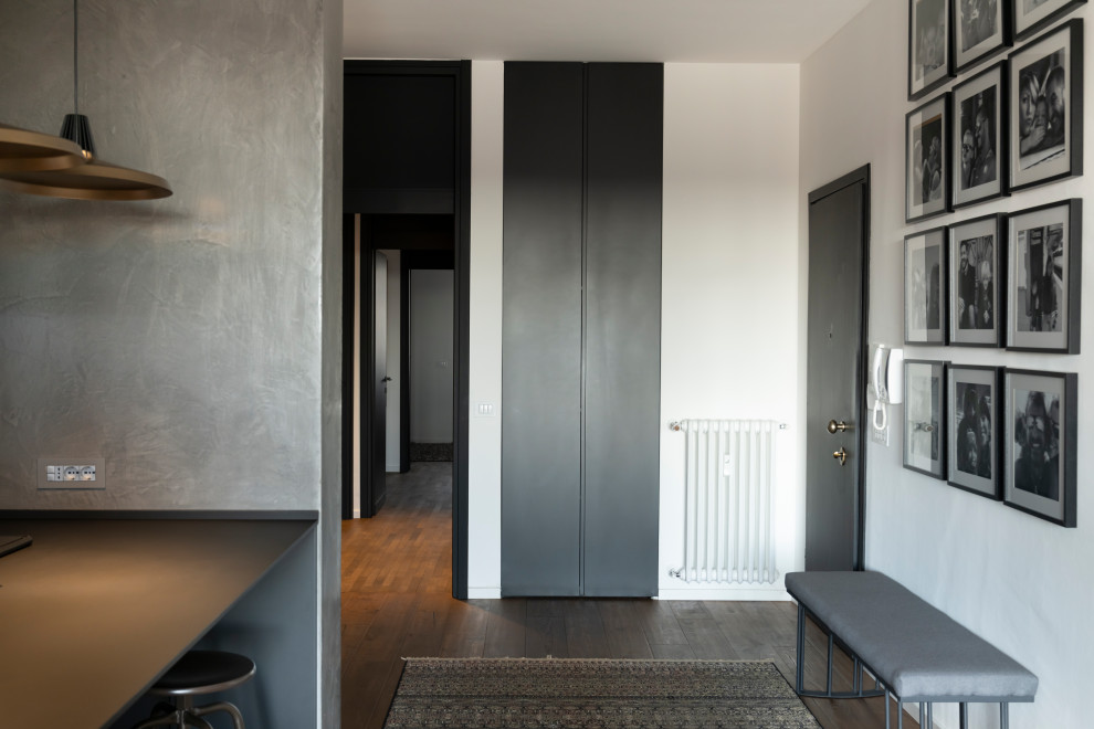 This is an example of a contemporary entryway in Milan with dark hardwood floors, a single front door and a black front door.