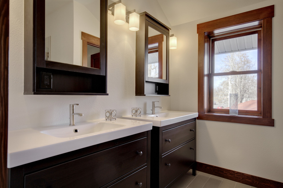 Modern bathroom in Denver with flat-panel cabinets, dark wood cabinets, beige walls and an integrated sink.
