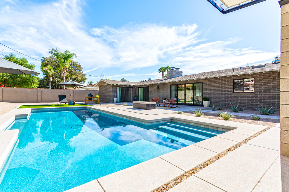 Midcentury backyard l-shaped pool in Phoenix with concrete slab.