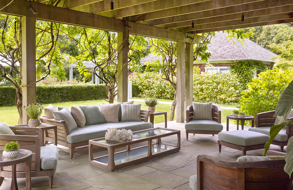 Large traditional backyard patio in New York with natural stone pavers and a pergola.