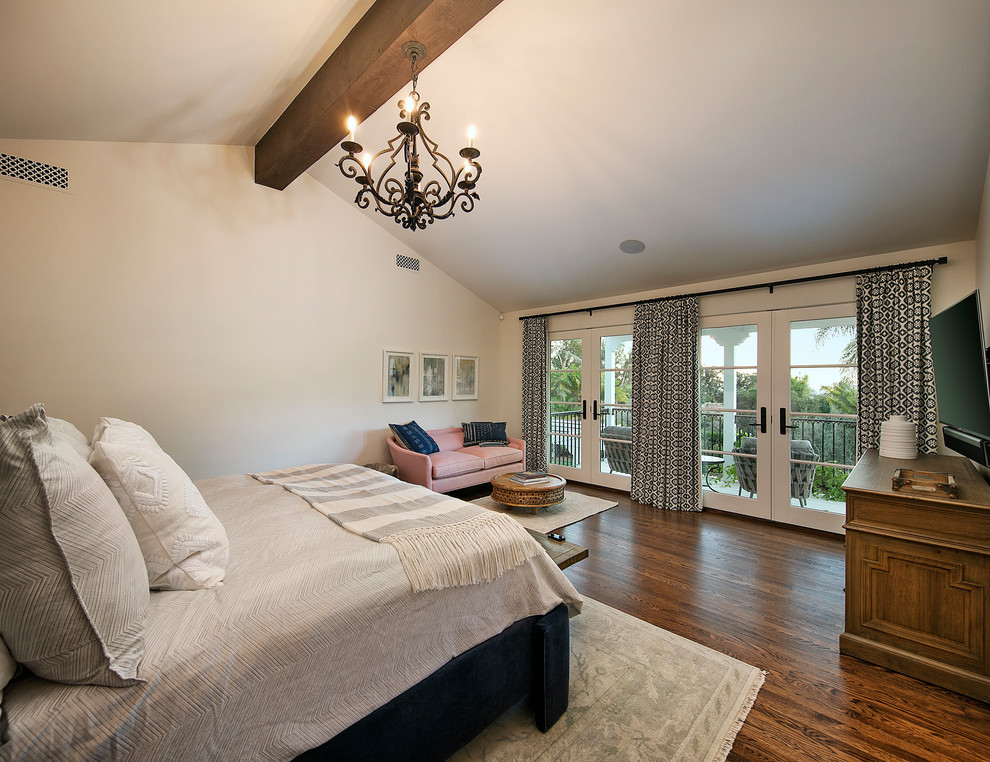 This is an example of a large mediterranean master bedroom in Santa Barbara with white walls, dark hardwood floors, no fireplace and brown floor.