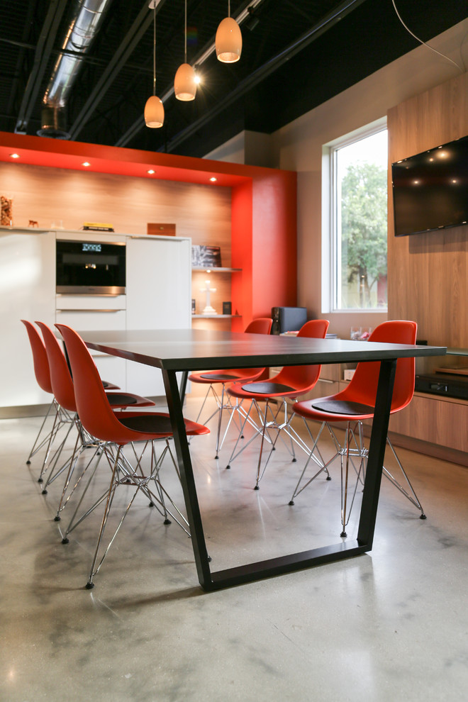 This is an example of a large modern kitchen/dining combo in Miami with orange walls, concrete floors and grey floor.