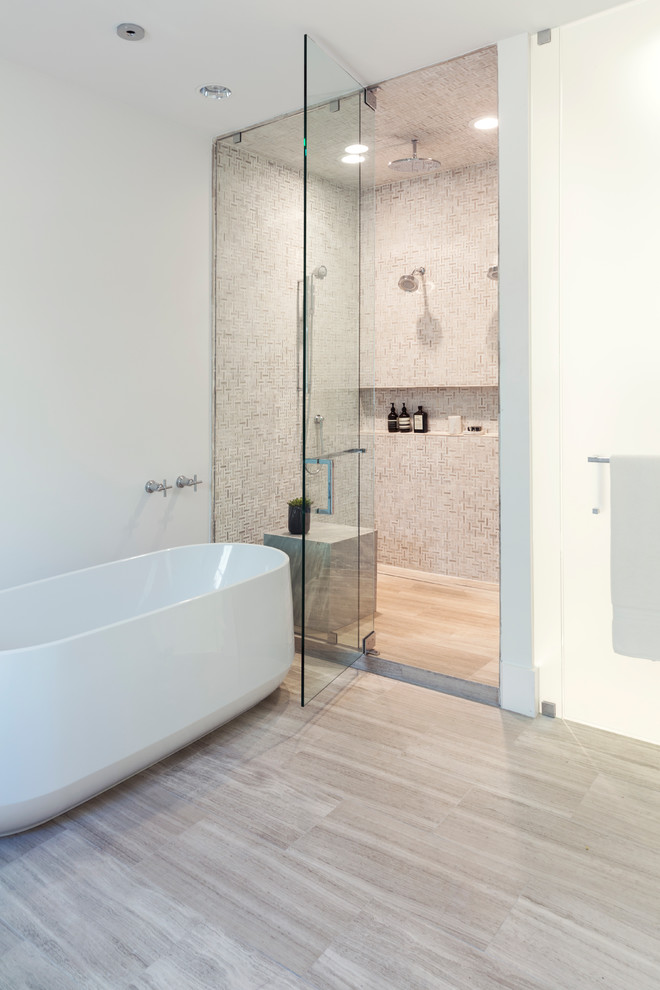 This is an example of a small contemporary master wet room bathroom in Dallas with shaker cabinets, white cabinets, a freestanding tub, a one-piece toilet, white tile, limestone, white walls, limestone floors, an undermount sink, quartzite benchtops, beige floor, a hinged shower door and grey benchtops.