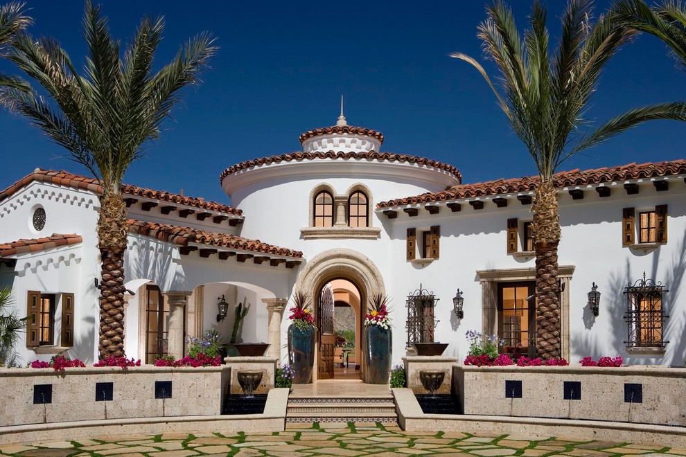 Inspiration for a mediterranean two-storey stucco white exterior in Orange County with a tile roof.