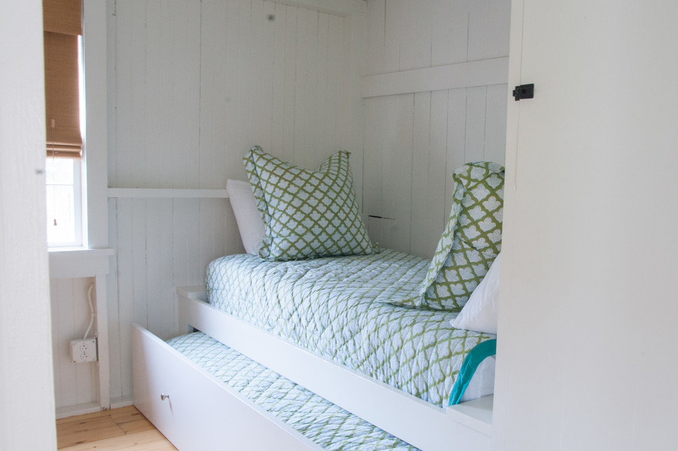 Mid-sized beach style guest medium tone wood floor bedroom photo in Other with white walls and no fireplace