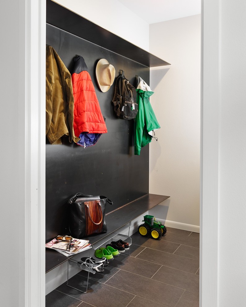 This is an example of a contemporary mudroom in Austin with grey walls and grey floor.