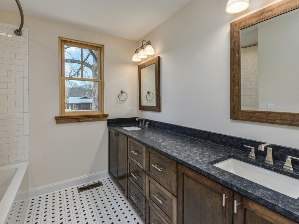 This is an example of a mid-sized country 3/4 bathroom in Other with shaker cabinets, dark wood cabinets, an alcove tub, a shower/bathtub combo, a two-piece toilet, white tile, subway tile, beige walls, mosaic tile floors, an undermount sink, granite benchtops, multi-coloured floor and a shower curtain.