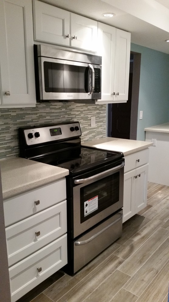 Transitional kitchen photo in Miami with gray backsplash and stainless steel appliances
