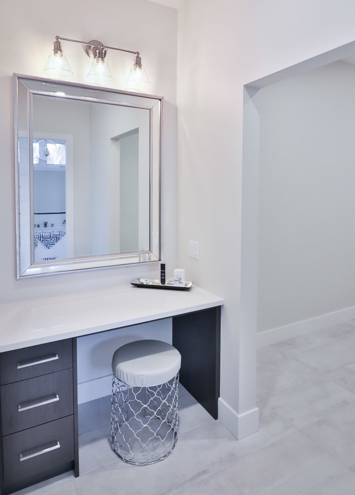 Inspiration for a large transitional master white tile and porcelain tile porcelain tile and gray floor drop-in bathtub remodel with flat-panel cabinets, gray cabinets, a one-piece toilet, gray walls, an undermount sink and quartz countertops