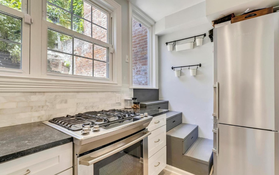 Enclosed kitchen - mid-sized transitional u-shaped medium tone wood floor and brown floor enclosed kitchen idea in DC Metro with an undermount sink, recessed-panel cabinets, white cabinets, granite countertops, white backsplash, marble backsplash, stainless steel appliances, a peninsula and black countertops