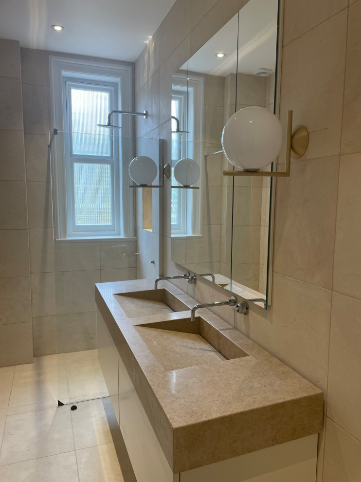Bathroom in London with limestone worktops, double sinks and a freestanding vanity unit.